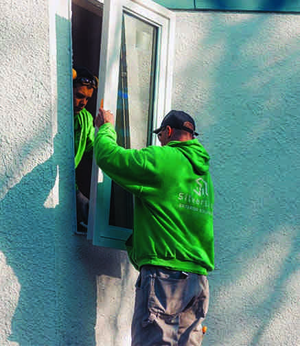 Silverline installer carefully fitting a new window on a local home